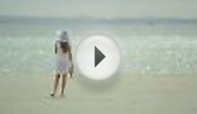 clip 50033158: Woman in a dress on the beach walks and